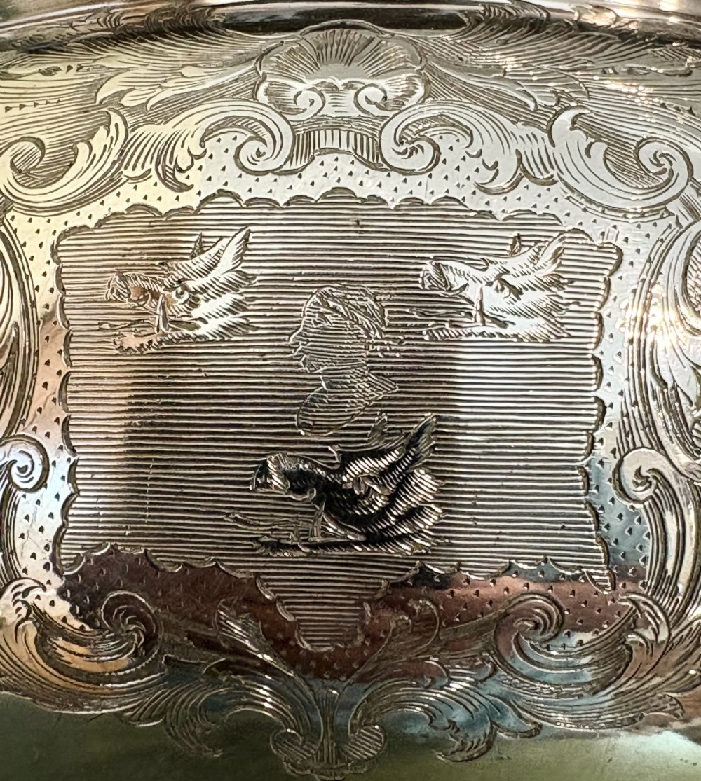 An antique silver-plated three-piece soup tureen featuring a domed lid with a scroll handle, engraved heraldic crest, and ornate scrolled feet. View V