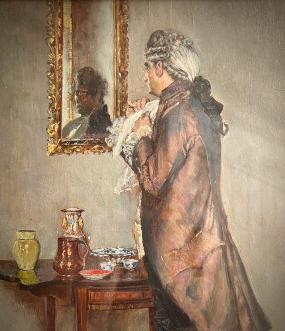 An antique oil painting depicting an 18th-century gentleman admiring his reflection in a wall mirror, housed within a deep moulded black frame with a gilded inner slip. View II