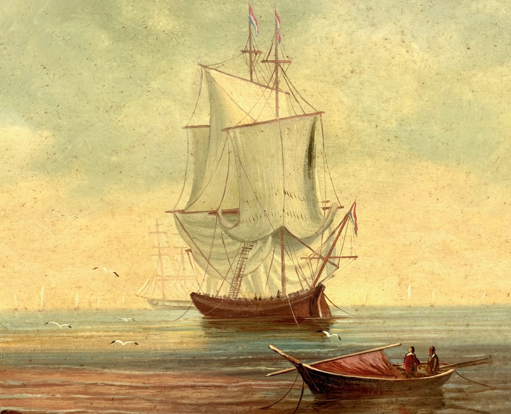 An antique oil painting on wood panel depicting sailing ships anchored along a sandy shore under a cloudy sky, held in an ornate gilt scrollwork frame. View III