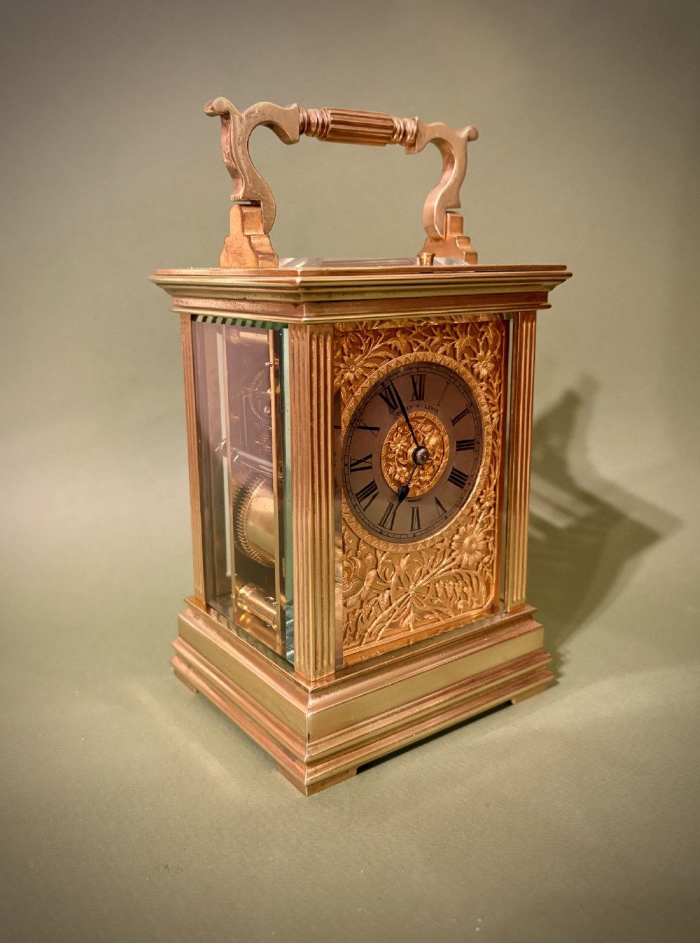 A gilt brass French repeating carriage clock with fluted corner columns, a silvered chapter ring, and a floral chased face. View III