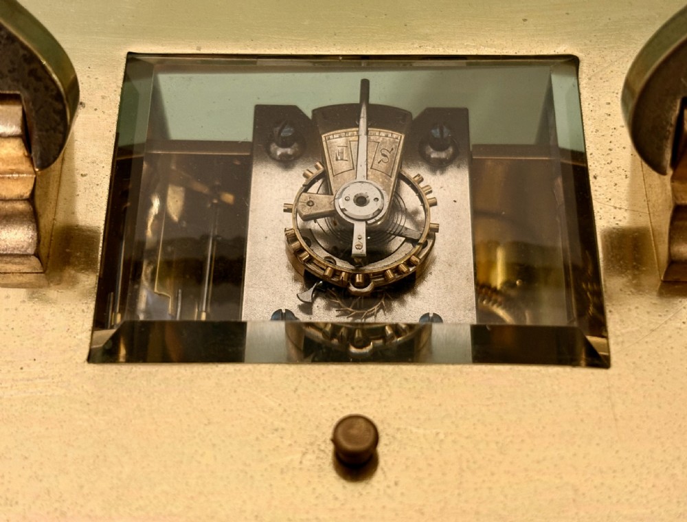 A gilt brass French repeating carriage clock with fluted corner columns, a silvered chapter ring, and a floral chased face. View VII