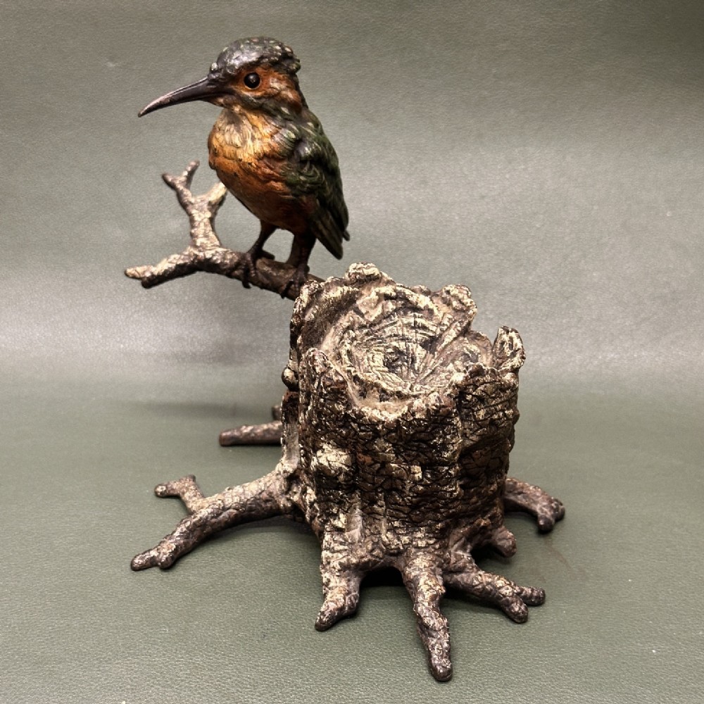 A cold painted bronze inkwell depicting a kingfisher bird perched on a branch above a tree stump base.