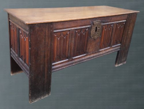 fig 1. A 17th-century dark oak coffer with carved linenfold front panels and a central metal escutcheon dated 1673.