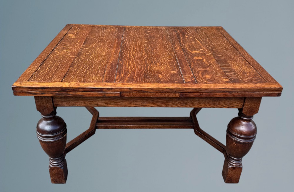 A rectangular warm brown oak draw-leaf dining table featuring heavy bulbous turned legs, low stretchers, and a quarter-sawn timber grain top. View II