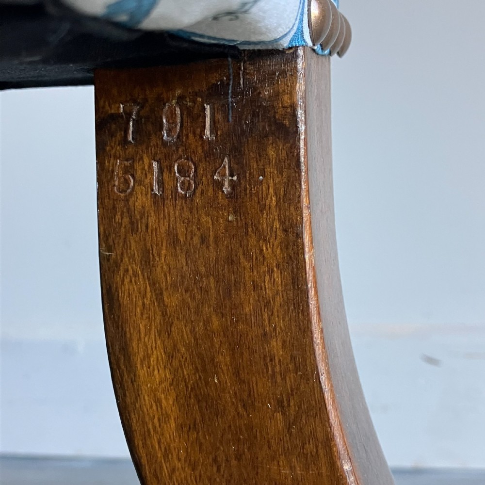A Victorian button-backed armchair upholstered in a blue and white botanical pattern with turned front legs on brass castors. View IV