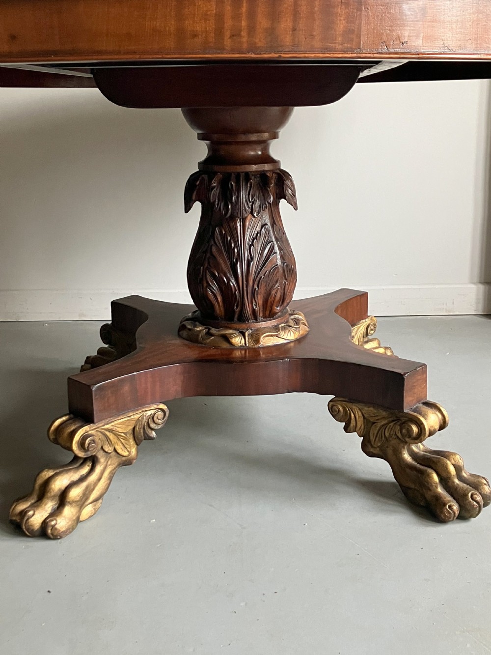 A circular mahogany centre table featuring a carved acanthus pedestal column and a quadform base with gilded claw feet. View III