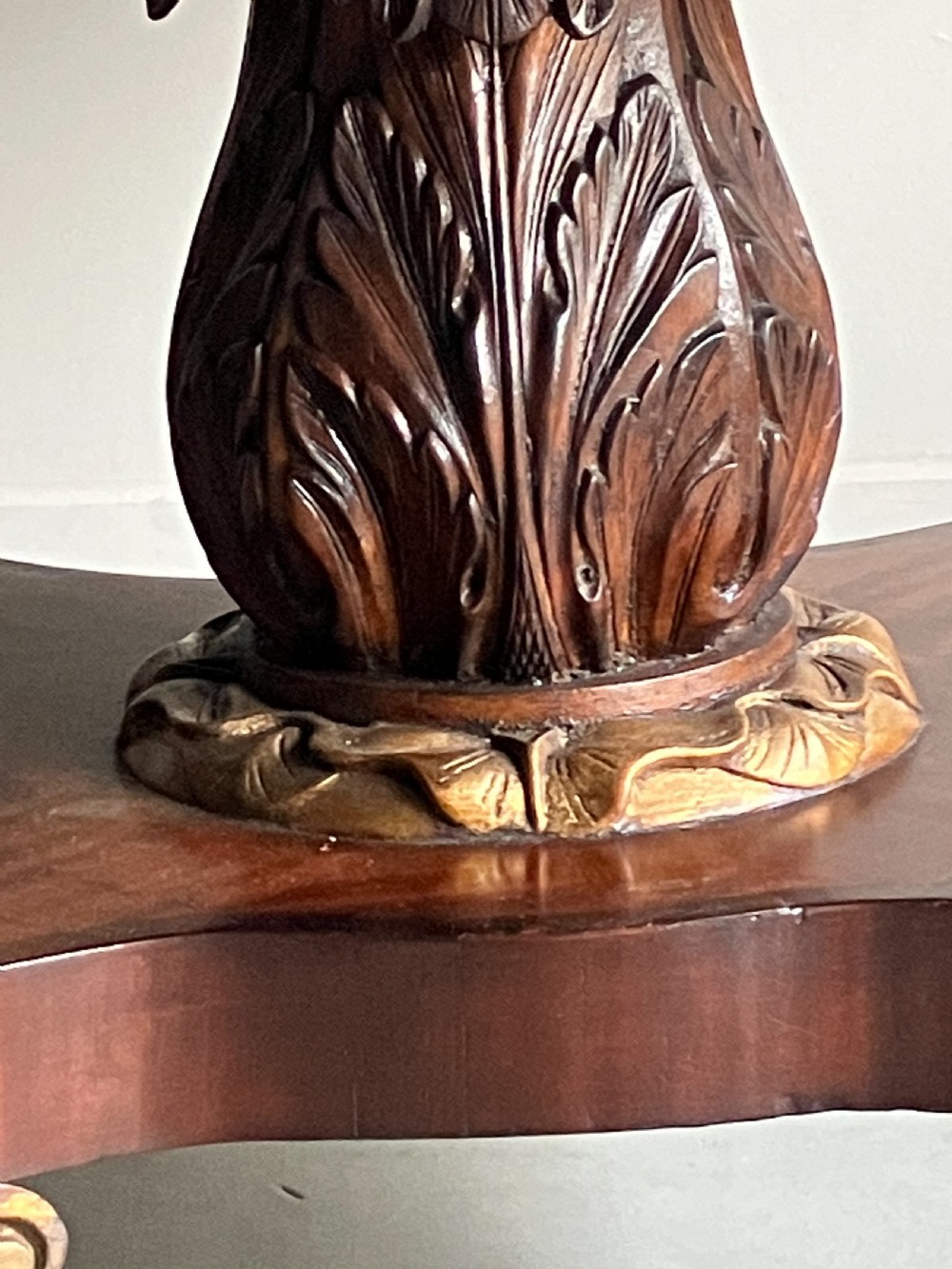 A circular mahogany centre table featuring a carved acanthus pedestal column and a quadform base with gilded claw feet. View V