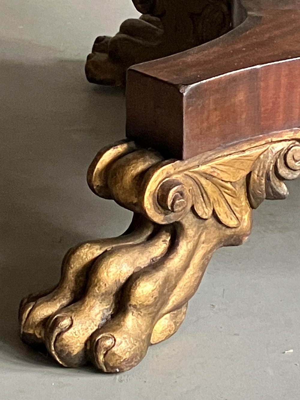 A circular mahogany centre table featuring a carved acanthus pedestal column and a quadform base with gilded claw feet. View VI
