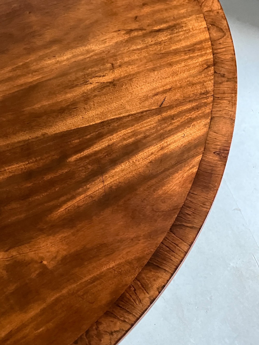 A circular mahogany centre table featuring a carved acanthus pedestal column and a quadform base with gilded claw feet. View X