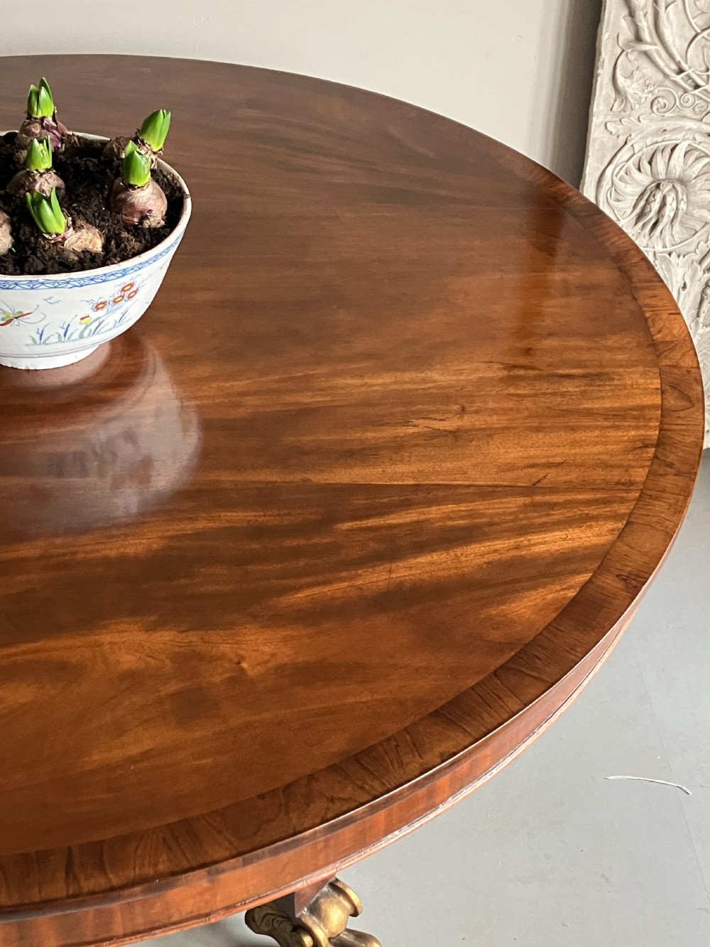 A circular mahogany centre table featuring a carved acanthus pedestal column and a quadform base with gilded claw feet. View XI