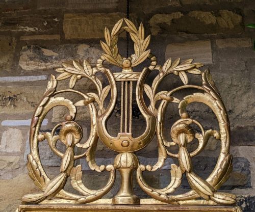 fig 2. An 18th-century French Directoire giltwood pier glass mirror featuring a carved lyre cresting flanked by foliate scrolls.