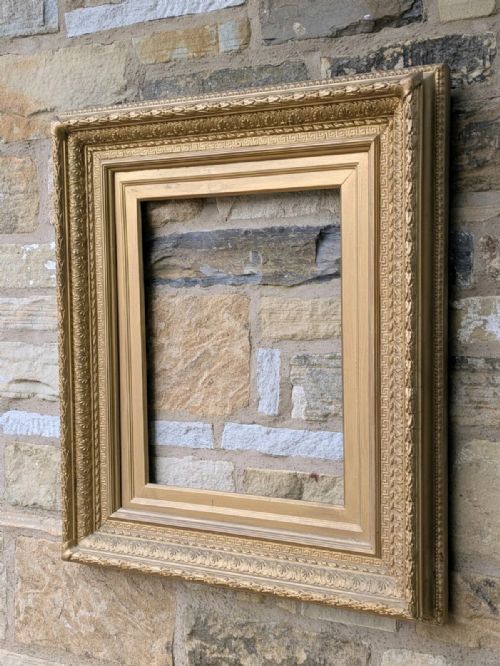 fig 1. A large rectangular Victorian giltwood frame featuring a classical Greek key inner border and relief-moulded leaf patterns along the outer edge.