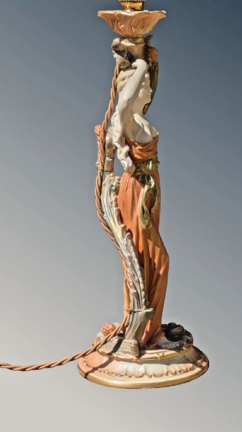 A Royal Worcester porcelain table lamp featuring a sculpted classical female figure in terracotta drapery beneath a pleated white shade. View IV