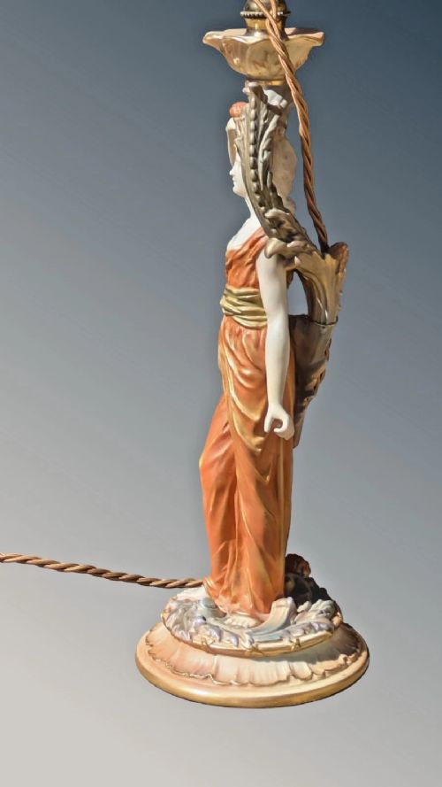 A Royal Worcester porcelain table lamp featuring a sculpted classical female figure in terracotta drapery beneath a pleated white shade. View VII