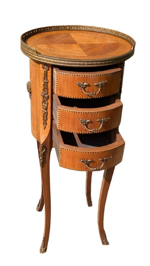 fig 2. An antique circular French kingwood bedside cabinet with three drawers, geometric parquetry inlay, ornate brass mounts, and cabriole legs.