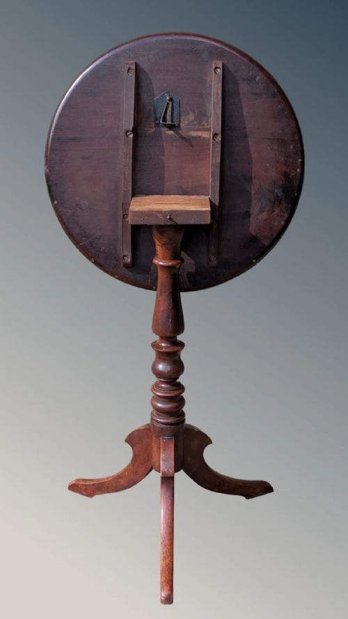 A Georgian mahogany circular tilt-top table featuring a turned central pedestal column resting on a tripod base. View VII