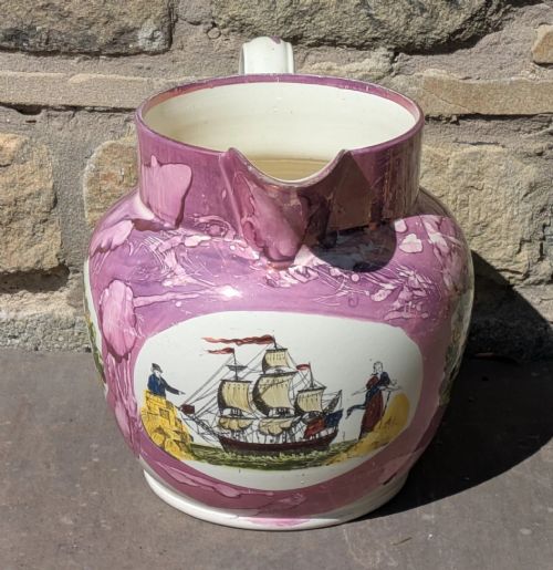 fig 1. An antique pink lustreware ceramic jug featuring marbled metallic pink glazing and a transfer-printed maritime verse in a central panel.