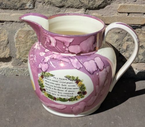 fig 2. An antique pink lustreware ceramic jug featuring marbled metallic pink glazing and a transfer-printed maritime verse in a central panel.