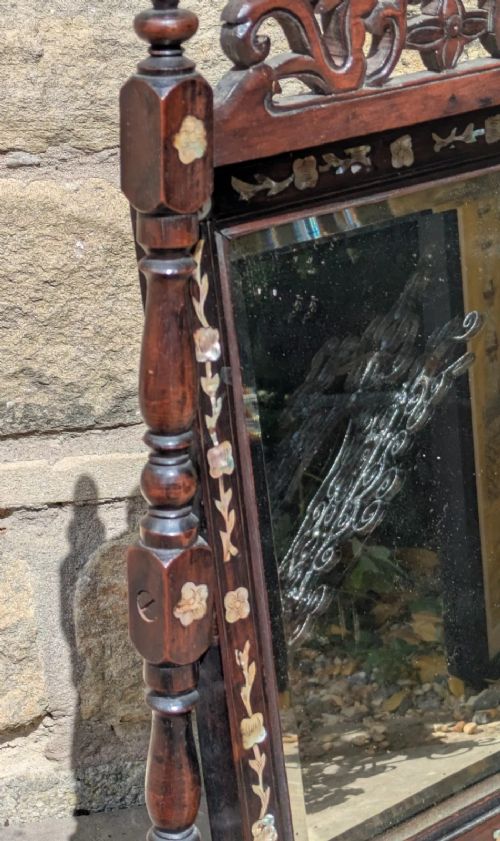 A dark hardwood tabletop cheval mirror featuring floral mother-of-pearl inlay, turned uprights, and a carved cresting top. View VI