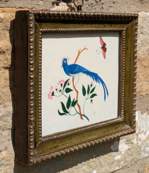 fig 1. A Regency watercolour illustration depicting a vivid blue bird perched on a branch alongside a pink butterfly, enclosed within an ornate beaded gilt frame.