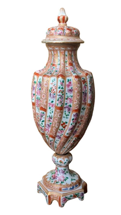 A pair of hand-painted porcelain lidded vases featuring fluted bodies, intricate floral motifs, geometric orange bands, and gilded details on square pedestals. View III