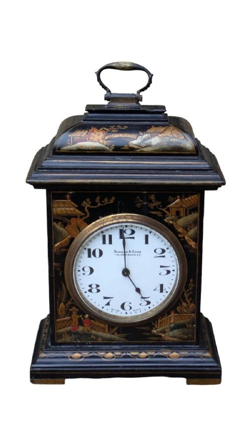 A black lacquered Regency style mantel clock decorated with gold hand-painted Chinoiserie landscapes, featuring a white circular dial with Arabic numerals and a top brass handle. View IV