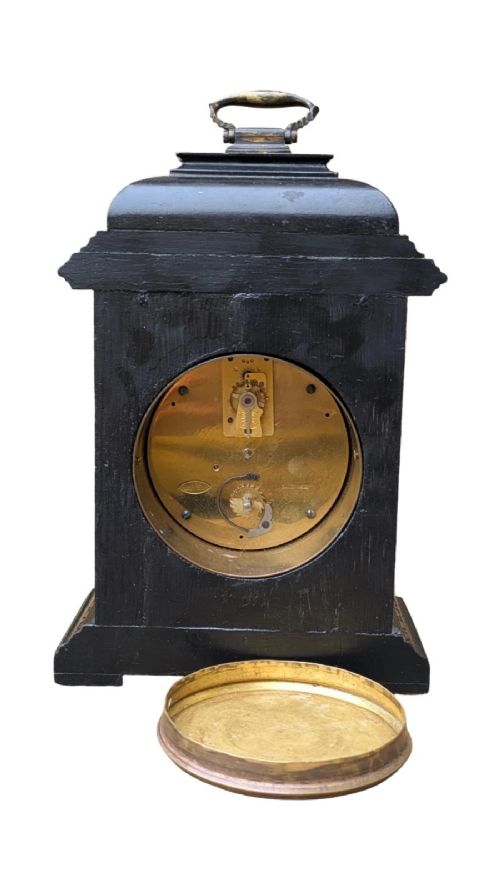 A black lacquered Regency style mantel clock decorated with gold hand-painted Chinoiserie landscapes, featuring a white circular dial with Arabic numerals and a top brass handle. View VIII