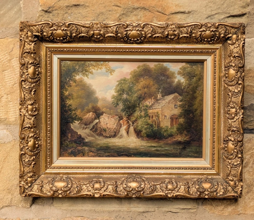 A 19th-century landscape oil painting depicting a stone watermill near a waterfall, displayed within an ornate gilded frame.