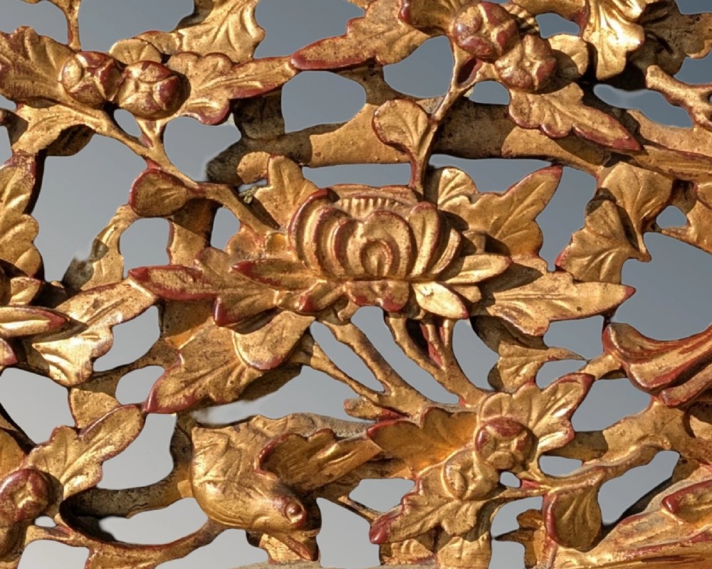 A pair of rectangular Chinese carved wood panels featuring openwork floral and bird motifs finished in gold gilding and framed by textured red lacquer borders. View VII