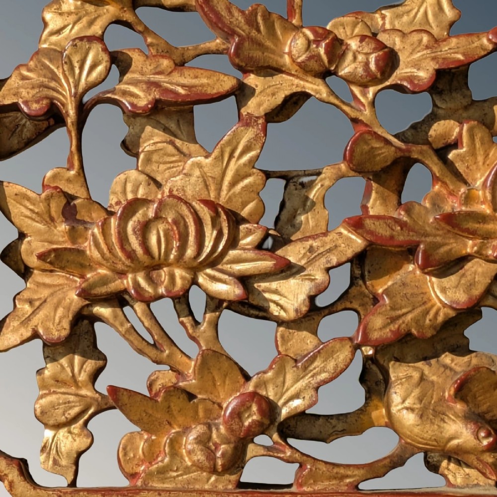 A pair of rectangular Chinese carved wood panels featuring openwork floral and bird motifs finished in gold gilding and framed by textured red lacquer borders. View VIII