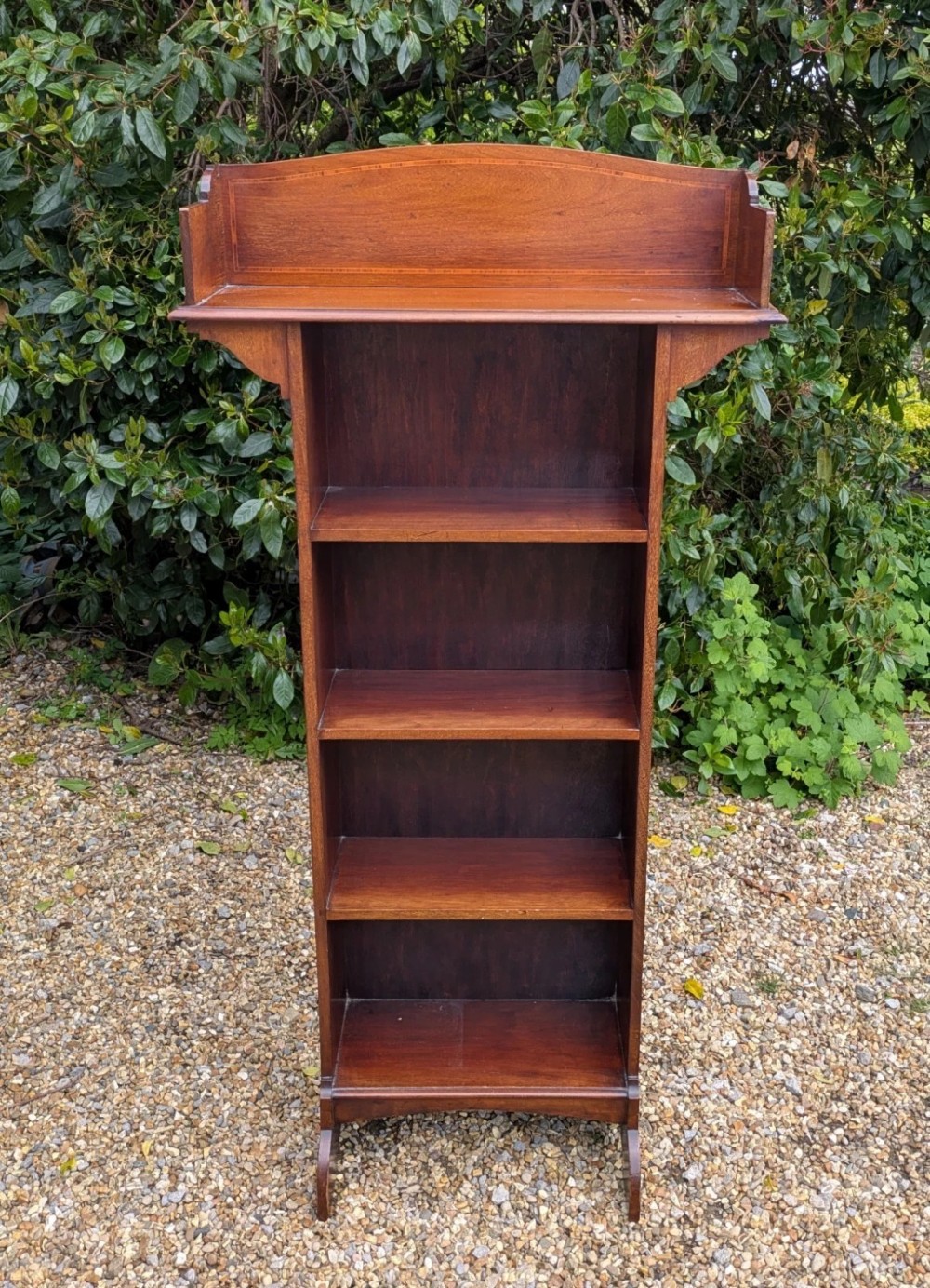A tall, narrow Edwardian mahogany open bookcase with string inlay, featuring four open shelves and a raised gallery back. View IV