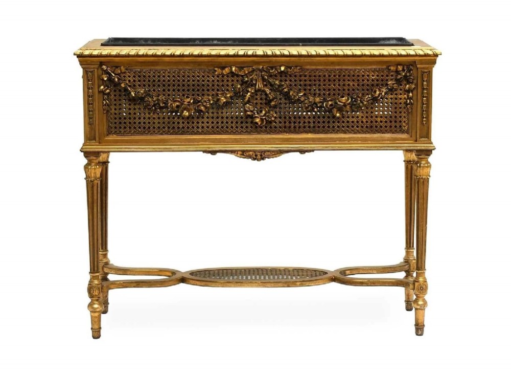 An antique Louis XVI style giltwood and cane jardiniere stand featuring carved floral swags, fluted legs, and an oval stretcher. View III