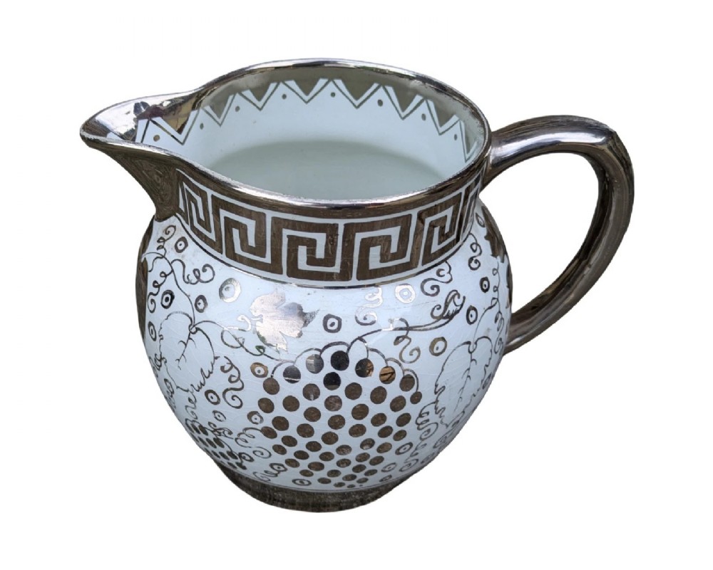 A white pearlware ceramic jug with silver lustre trim, featuring a Greek key band along the neck and a grape and vine pattern around the body. View II