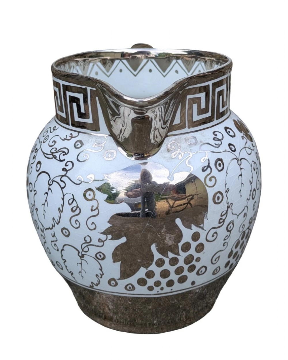 A white pearlware ceramic jug with silver lustre trim, featuring a Greek key band along the neck and a grape and vine pattern around the body. View IV