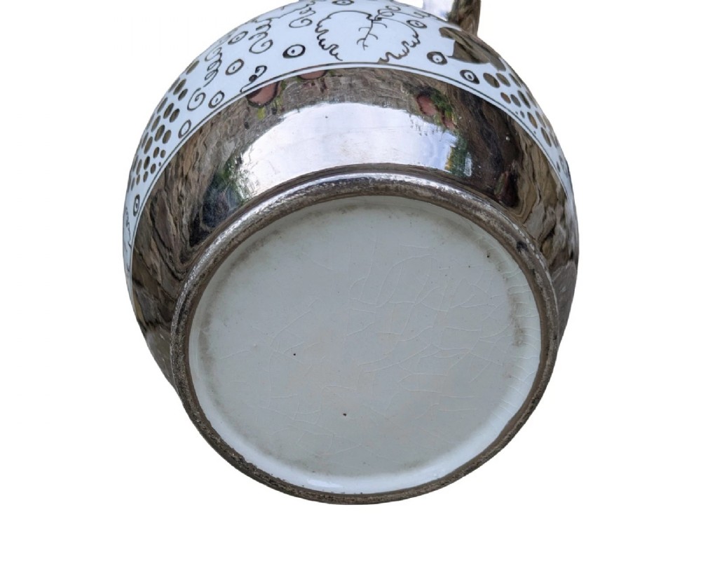 A white pearlware ceramic jug with silver lustre trim, featuring a Greek key band along the neck and a grape and vine pattern around the body. View VII