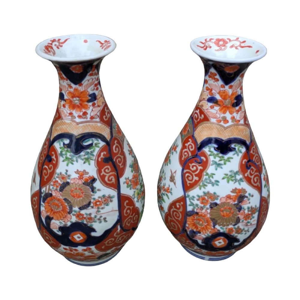 A pair of pear-shaped Japanese Imari porcelain vases decorated with cobalt blue, iron-red, and gold floral panels.