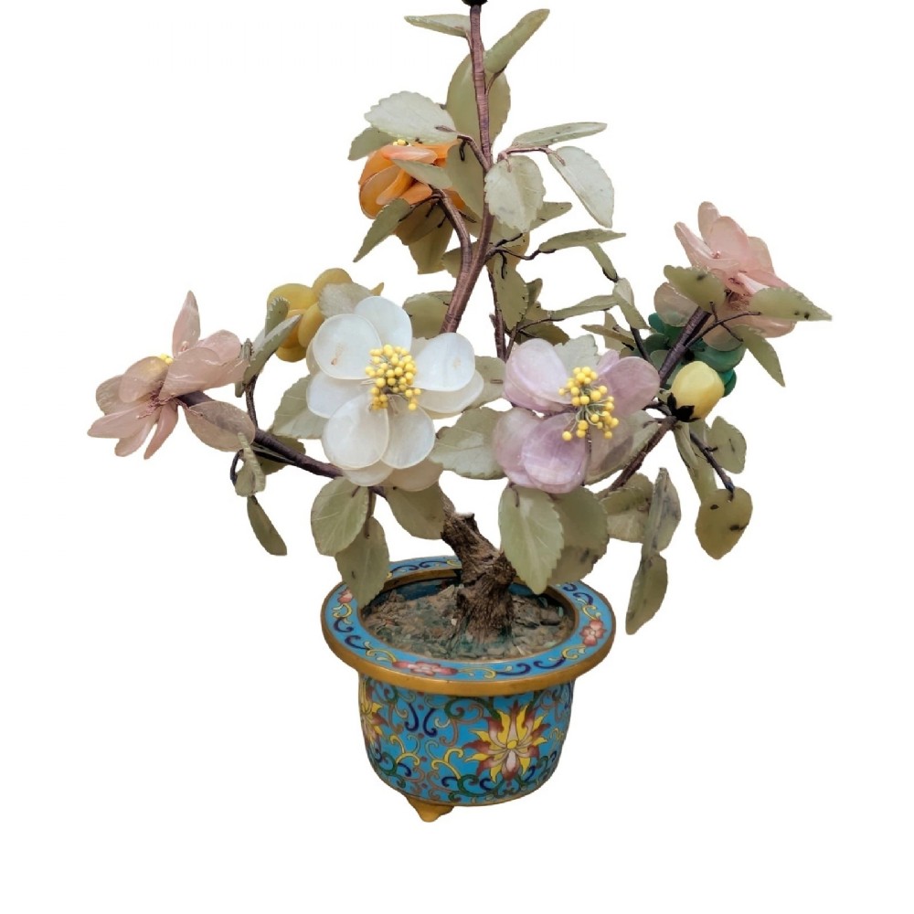 A Chinese ornamental bonsai tree featuring carved hardstone leaves and petals set inside a turquoise floral cloisonne planter.
