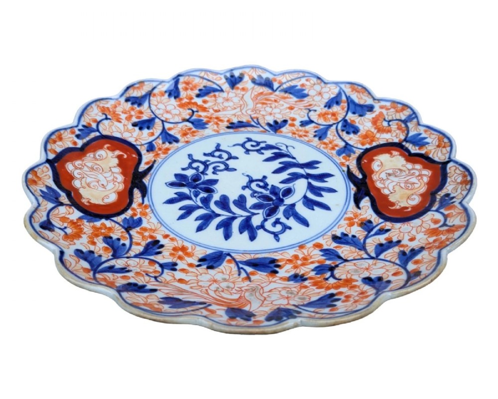 A circular Japanese Imari porcelain charger featuring a scalloped rim, hand-painted cobalt blue and iron red floral patterns, and a central botanical roundel. View II