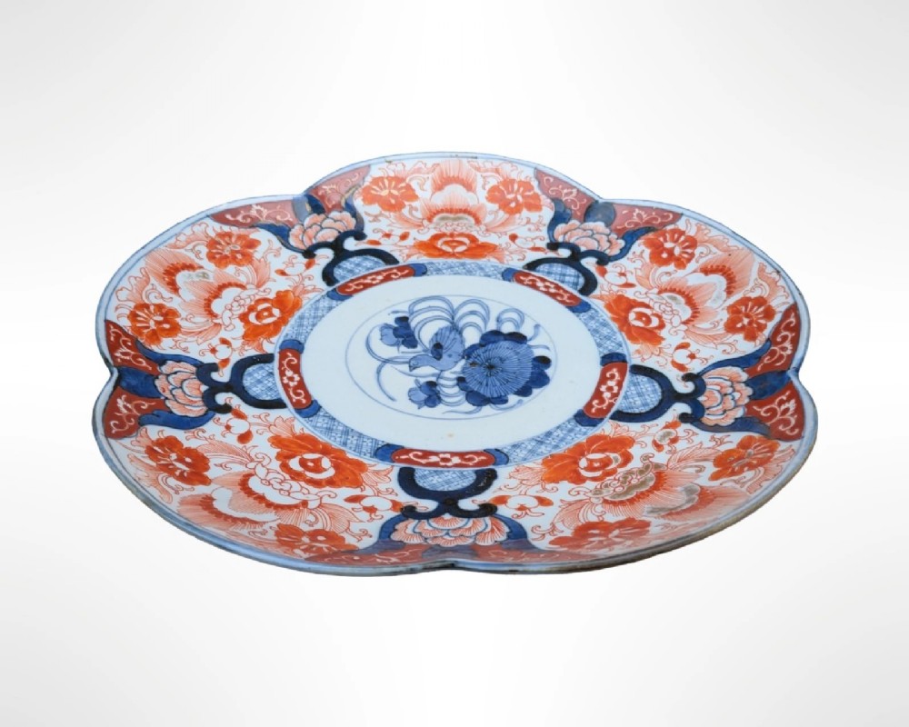 A lobed Japanese Imari porcelain dish featuring red floral patterns, blue underglaze details, and a central circular medallion depicting a bird. View II