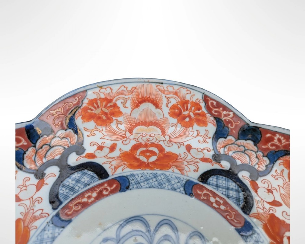 A lobed Japanese Imari porcelain dish featuring red floral patterns, blue underglaze details, and a central circular medallion depicting a bird. View III