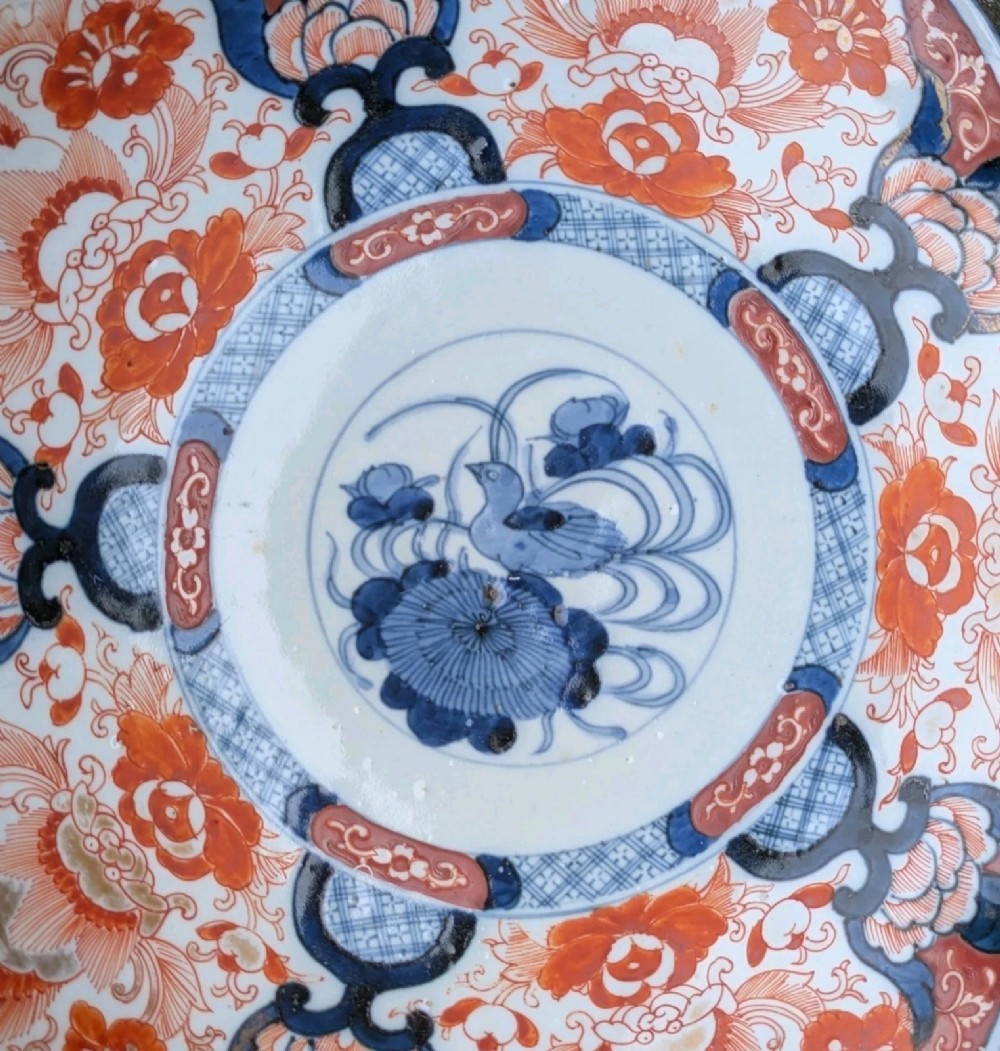 A lobed Japanese Imari porcelain dish featuring red floral patterns, blue underglaze details, and a central circular medallion depicting a bird. View IV