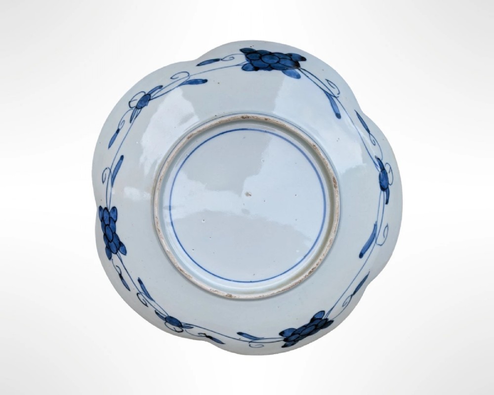 A lobed Japanese Imari porcelain dish featuring red floral patterns, blue underglaze details, and a central circular medallion depicting a bird. View V