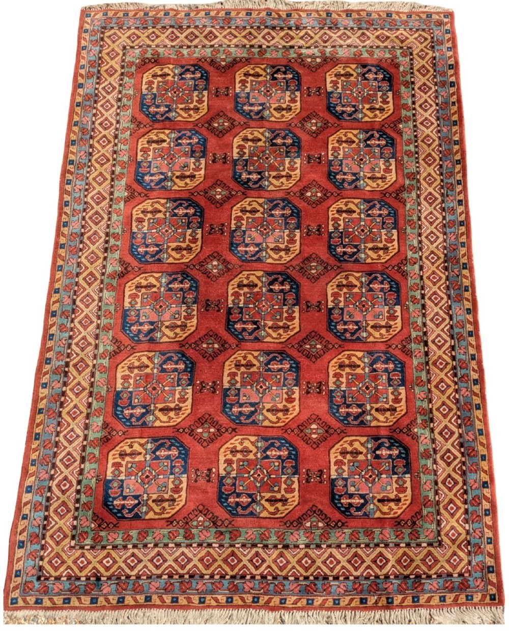 A hand-knotted rectangular wool carpet featuring repeating octagonal tribal gul motifs on a deep red field framed by geometric borders.