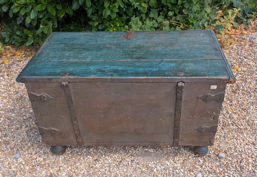 A rectangular teal blue painted pine storage chest featuring hand-forged iron strapwork, corner brackets, and turned bun feet. View VIII