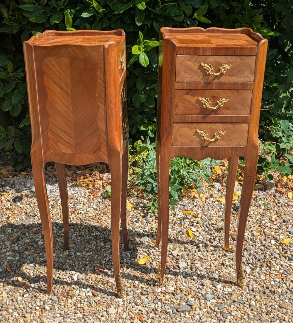 A pair of tall, slim French Louis XV style bedside cabinets crafted with geometric wood parquetry, featuring three drawers with ornate gilt handles and long cabriole legs with metal sabots. View VI