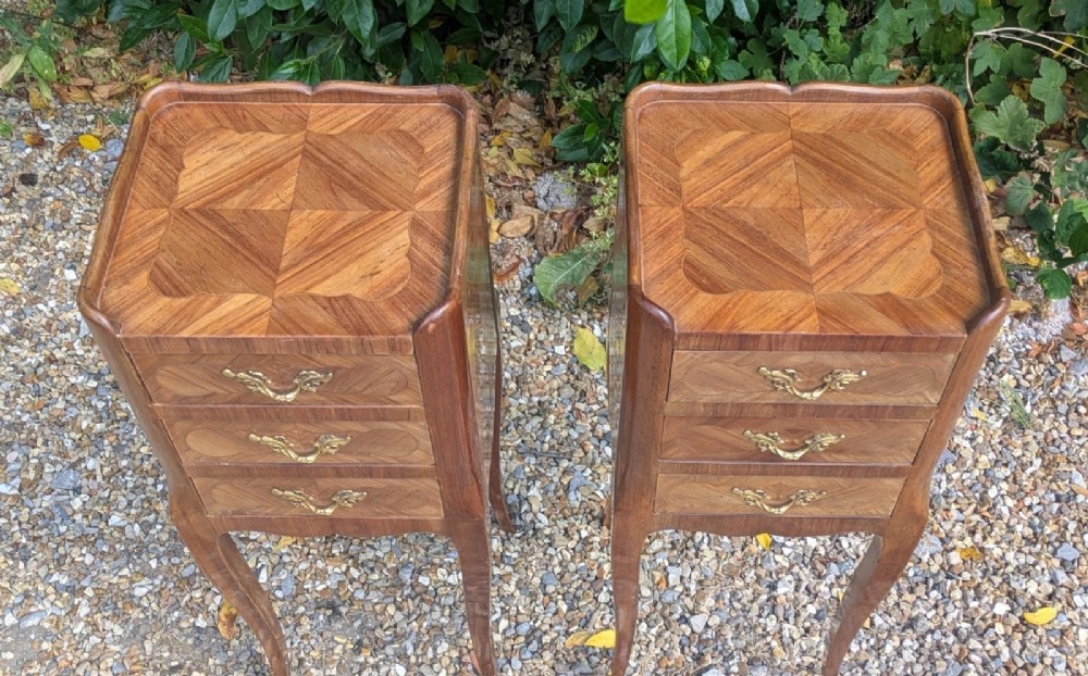 A pair of tall, slim French Louis XV style bedside cabinets crafted with geometric wood parquetry, featuring three drawers with ornate gilt handles and long cabriole legs with metal sabots. View VII