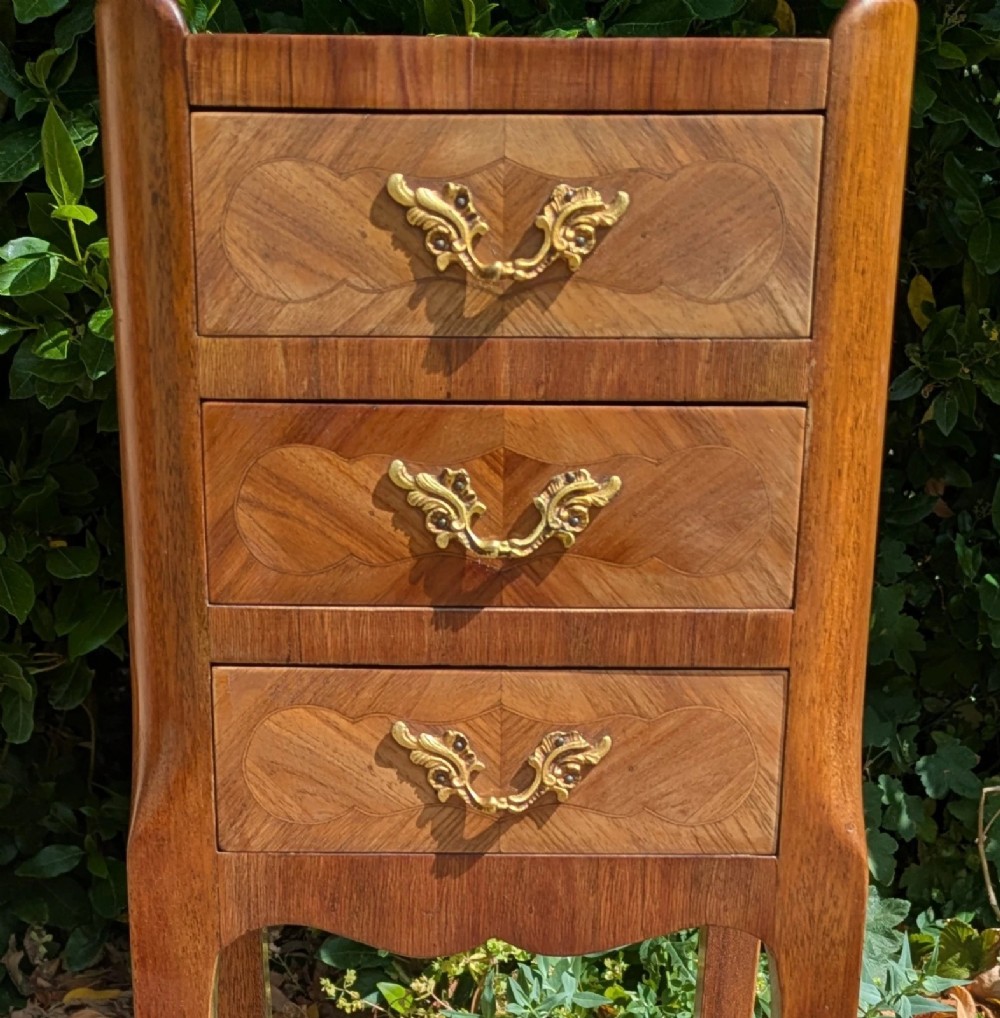 A pair of tall, slim French Louis XV style bedside cabinets crafted with geometric wood parquetry, featuring three drawers with ornate gilt handles and long cabriole legs with metal sabots. View VIII