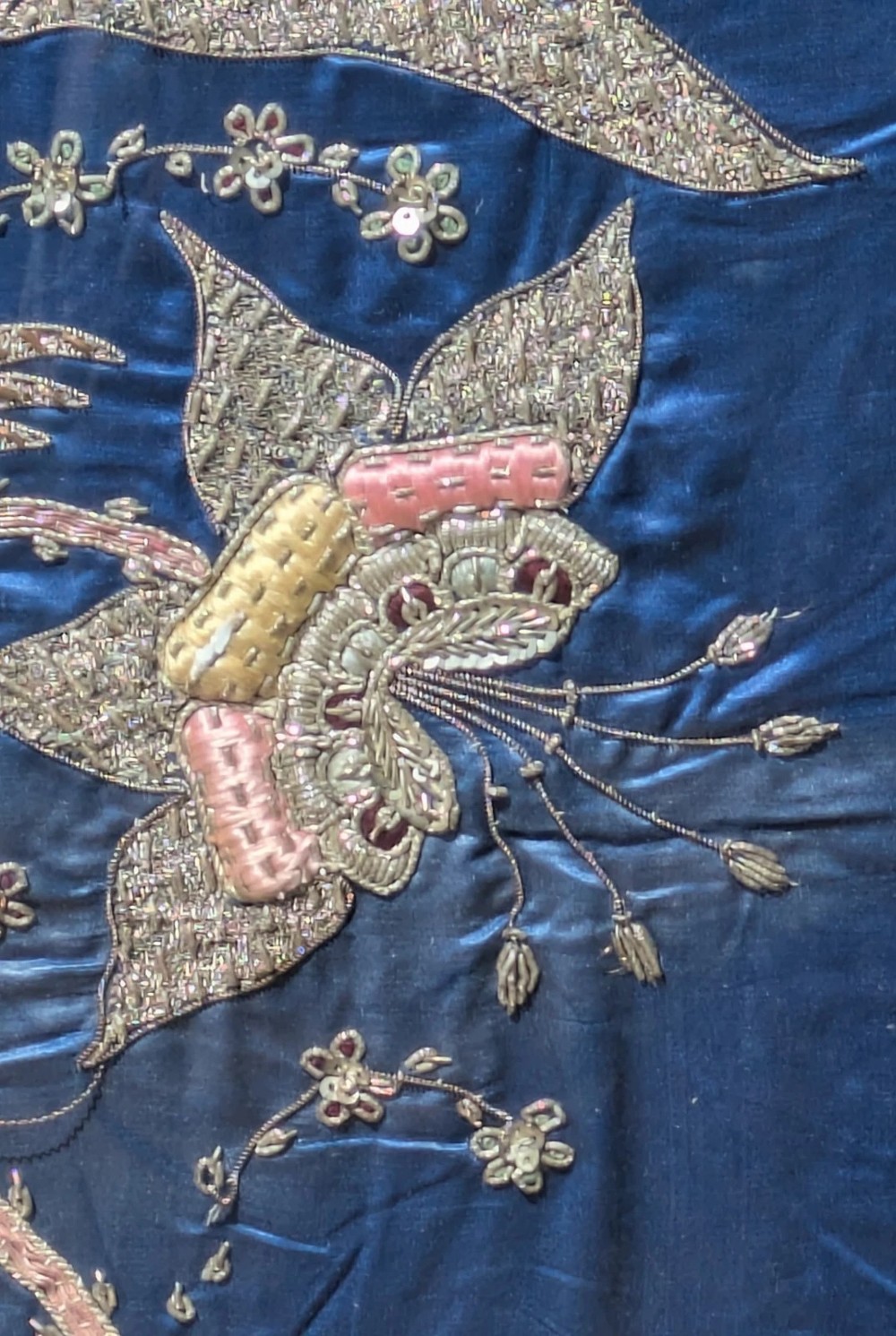 A framed vertical silk textile panel displaying metallic thread zardozi embroidery of peacocks, flowers, and the Taj Mahal on a cobalt blue ground. View IV
