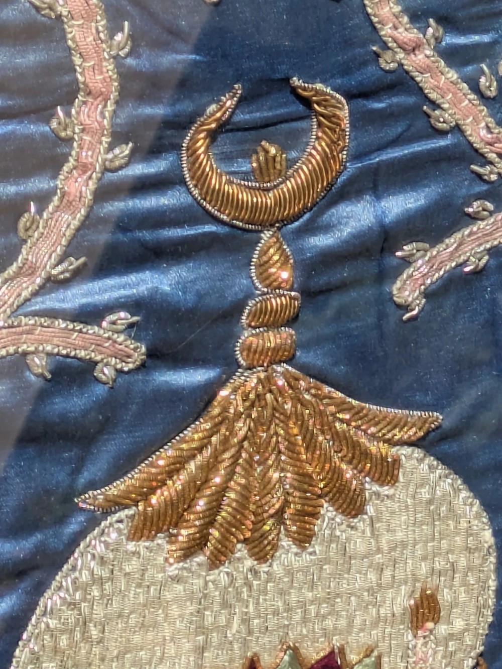 A framed vertical silk textile panel displaying metallic thread zardozi embroidery of peacocks, flowers, and the Taj Mahal on a cobalt blue ground. View VII