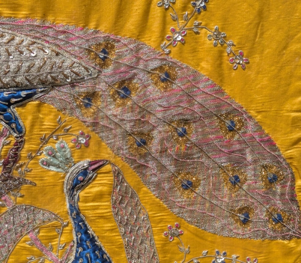 Framed vertical yellow silk panel embroidered with two peacocks, floral motifs, and an architectural depiction of the Taj Mahal in metallic thread. View V
